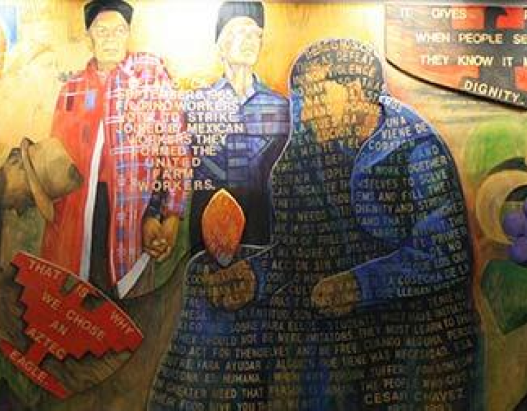 A mural showing farmers and labor rights activism with a quote.