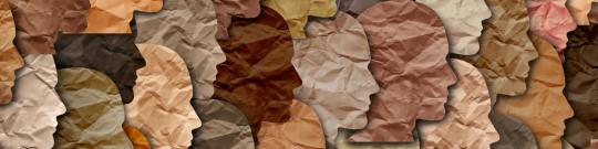 A bunch of diverse crumbled paper face cutouts looking to the right