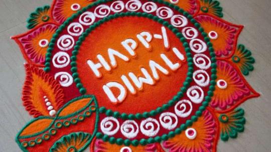 Colorful rangoli design with the words "Happy Diwali" in the center, surrounded by intricate patterns of swirls, petals, and diyas in vibrant colors like red, orange, green, and white